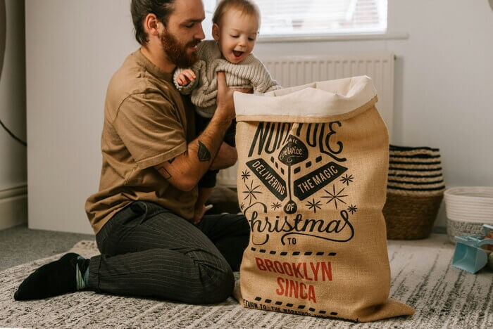 Un homme et son bébé regardant un sac contenant des cadeaux